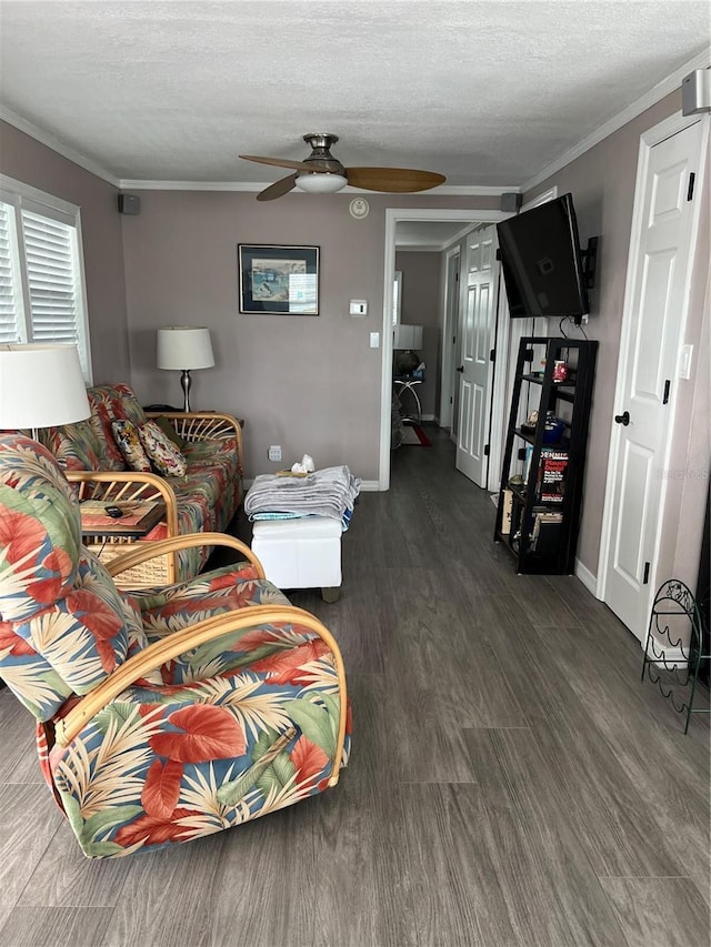 living room with ceiling fan, dark hardwood / wood-style floors, a textured ceiling, and ornamental molding