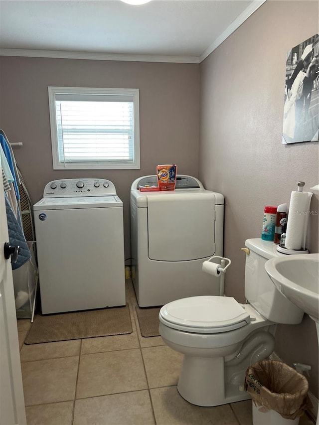 bathroom featuring tile patterned flooring, toilet, separate washer and dryer, and crown molding