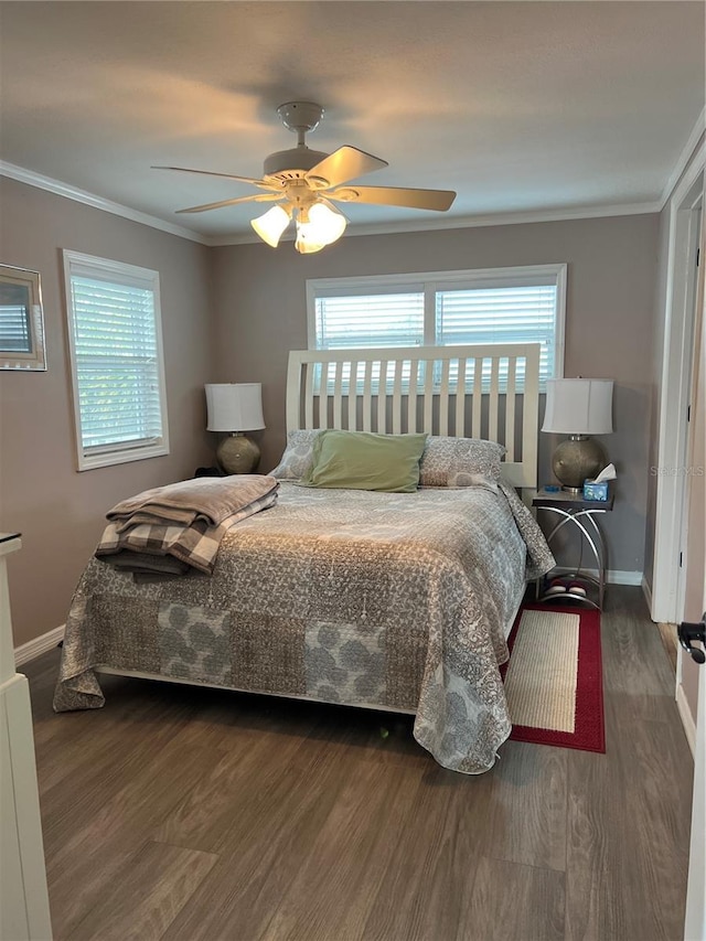 bedroom with multiple windows, dark hardwood / wood-style floors, ceiling fan, and ornamental molding