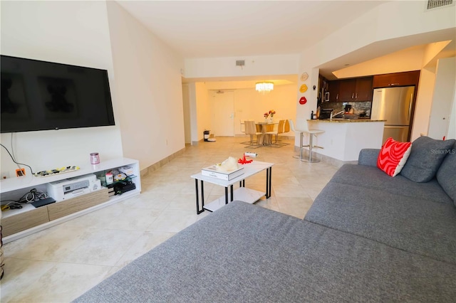 living room with light tile patterned floors and a chandelier