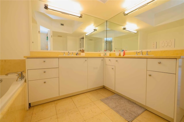 bathroom with tiled bath, tile patterned flooring, and vanity