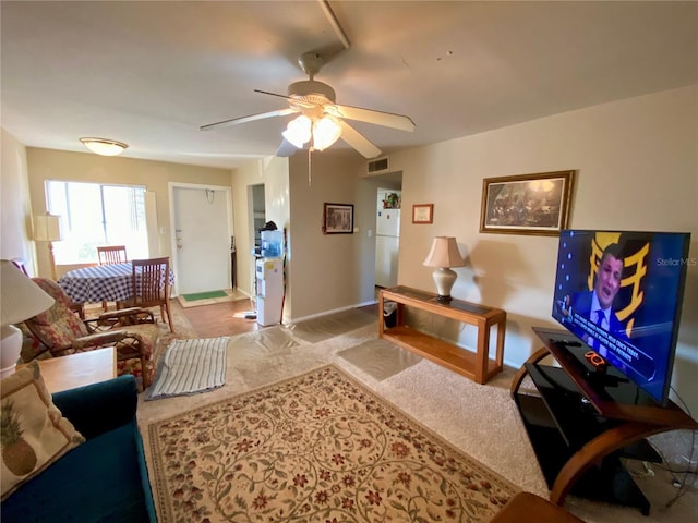 carpeted living room with ceiling fan