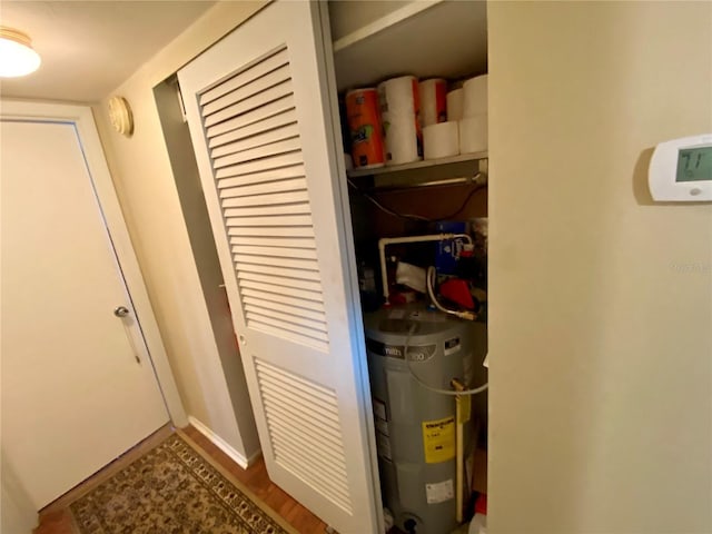 utility room featuring strapped water heater