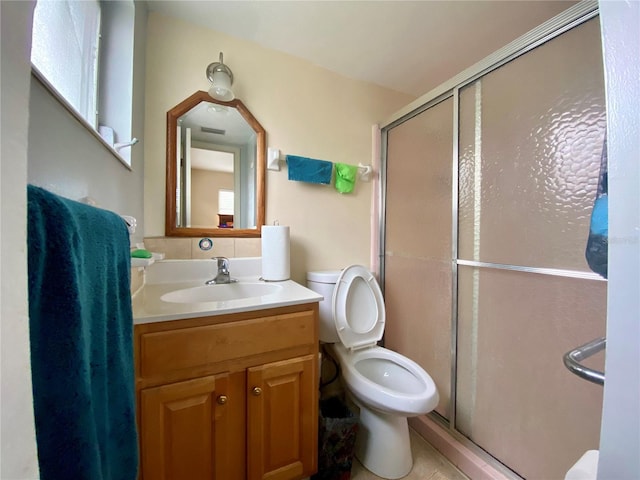 bathroom with walk in shower, vanity, and toilet