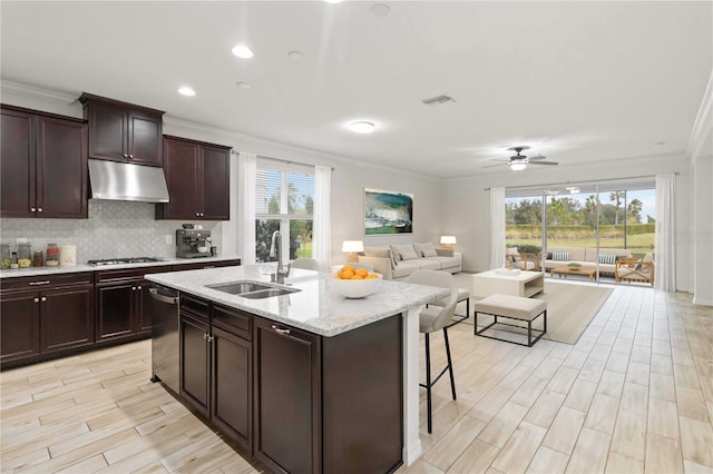 kitchen with sink, ceiling fan, a center island with sink, crown molding, and appliances with stainless steel finishes