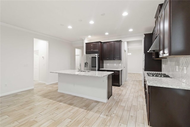 kitchen featuring tasteful backsplash, stainless steel appliances, a kitchen island with sink, and wall chimney exhaust hood