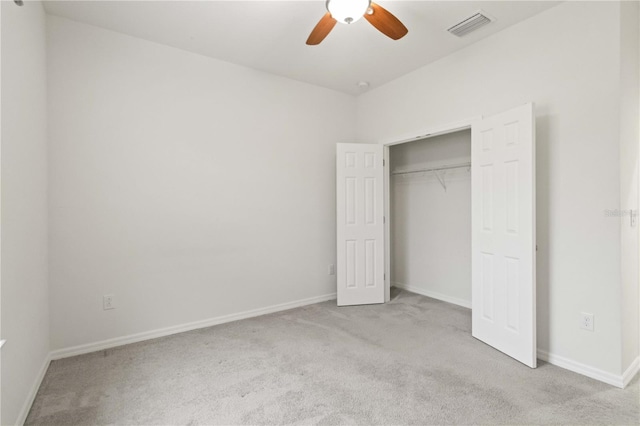 unfurnished bedroom with light colored carpet, ceiling fan, and a closet