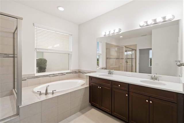 bathroom featuring tile patterned flooring, vanity, and shower with separate bathtub