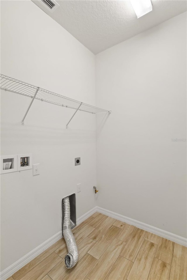 clothes washing area with hookup for a gas dryer, washer hookup, light hardwood / wood-style flooring, and hookup for an electric dryer