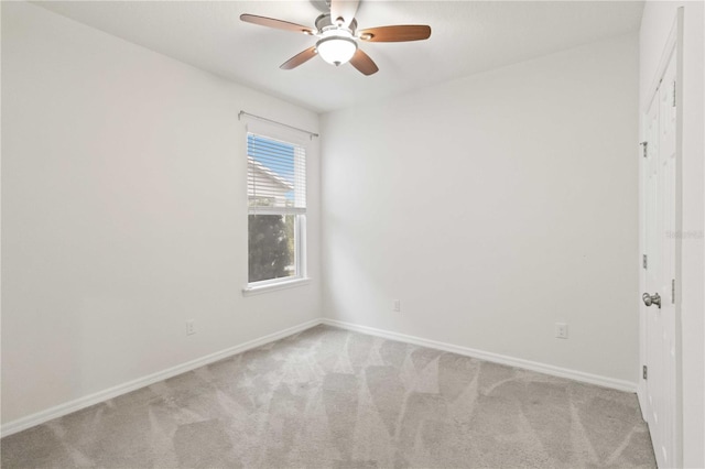 spare room featuring light carpet and ceiling fan