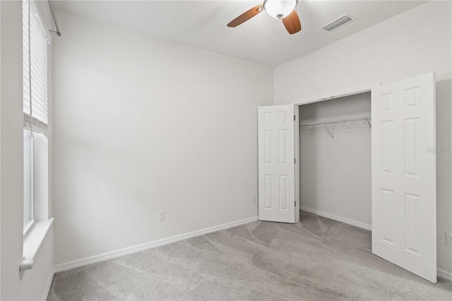 unfurnished bedroom with ceiling fan, a closet, and light carpet