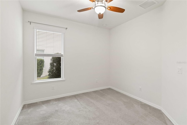 spare room featuring light carpet and ceiling fan