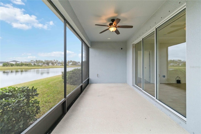 sunroom featuring plenty of natural light, ceiling fan, and a water view