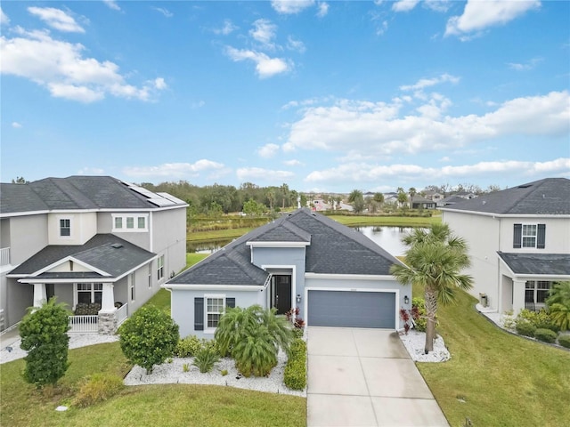 view of front of house featuring a porch, a water view, solar panels, a garage, and a front yard