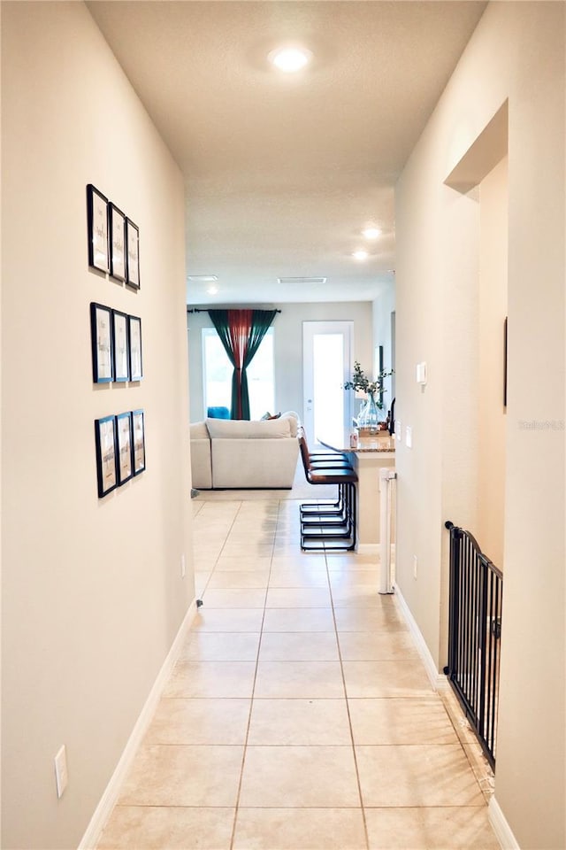 corridor featuring light tile patterned floors