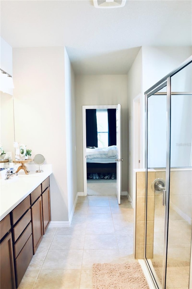 bathroom with walk in shower, vanity, and tile patterned flooring