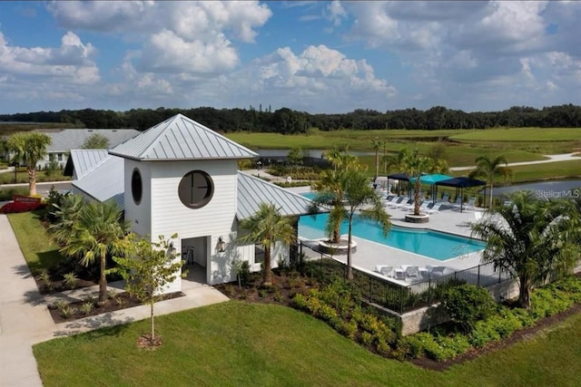 view of pool with a patio area and a lawn