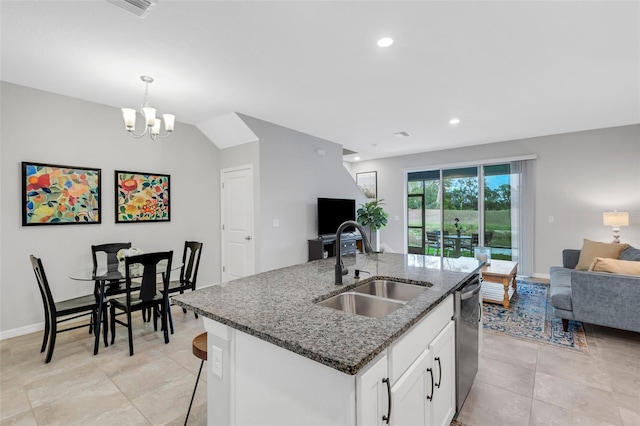 kitchen with dishwasher, sink, a kitchen island with sink, white cabinets, and dark stone counters