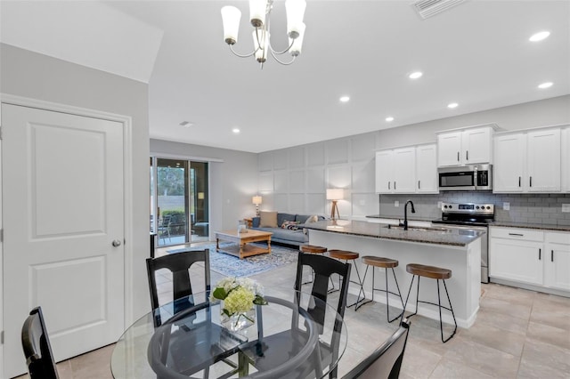 dining space featuring sink, a chandelier, and light tile patterned flooring