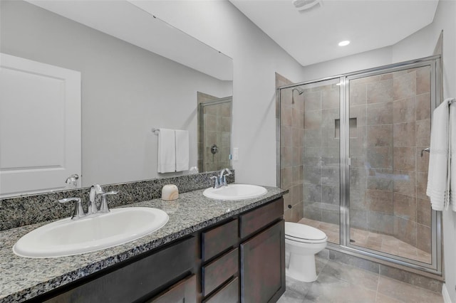 bathroom featuring a shower with door, toilet, and vanity