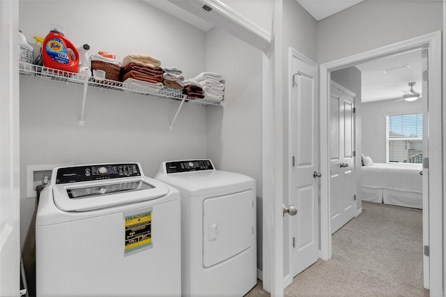 laundry room with washing machine and dryer, ceiling fan, and light colored carpet