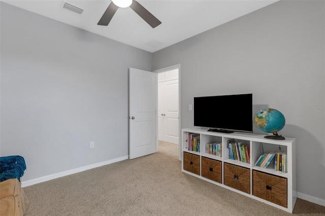 interior space with light carpet and ceiling fan