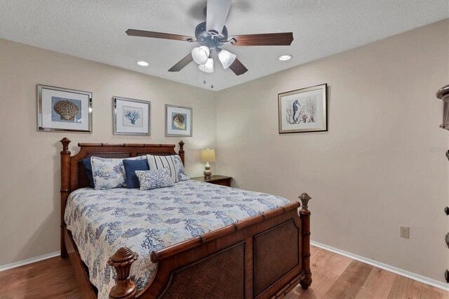 bedroom featuring a textured ceiling, ceiling fan, and wood-type flooring