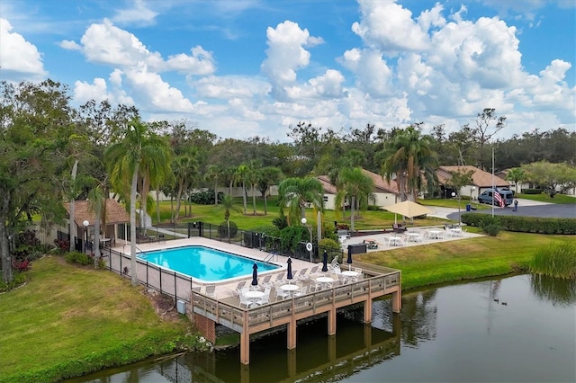 view of swimming pool with a yard and a water view