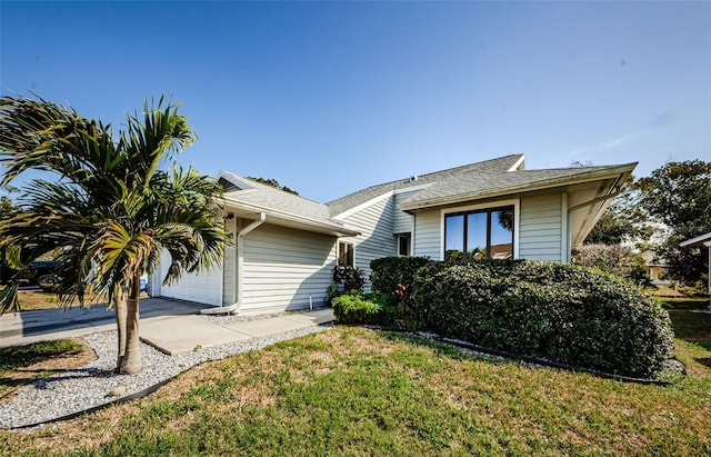 view of front of property featuring a front lawn and a garage