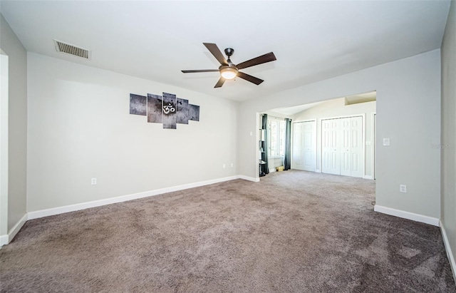 empty room with dark carpet and ceiling fan