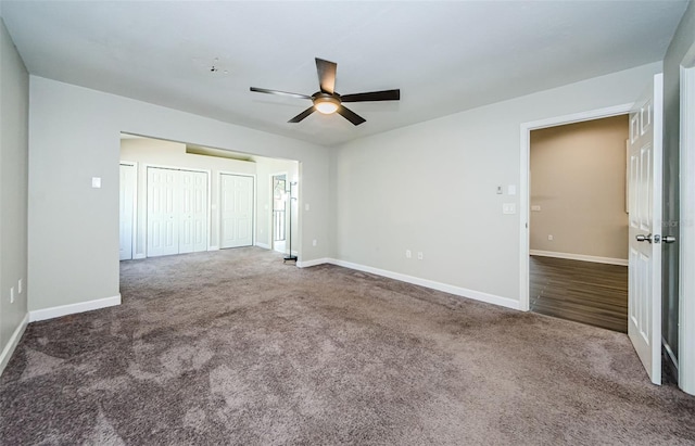 unfurnished bedroom featuring dark colored carpet and ceiling fan