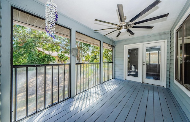 unfurnished sunroom featuring ceiling fan and plenty of natural light