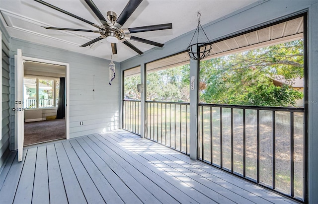 unfurnished sunroom with ceiling fan