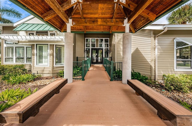 view of exterior entry featuring a pergola and french doors