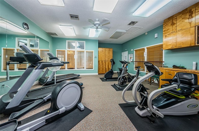 gym featuring ceiling fan and a textured ceiling