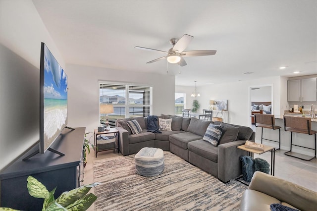 living room with ceiling fan with notable chandelier