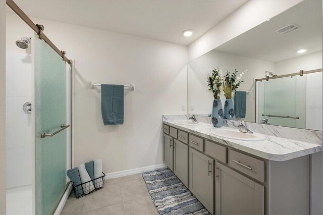 bathroom featuring tile patterned flooring, walk in shower, and vanity