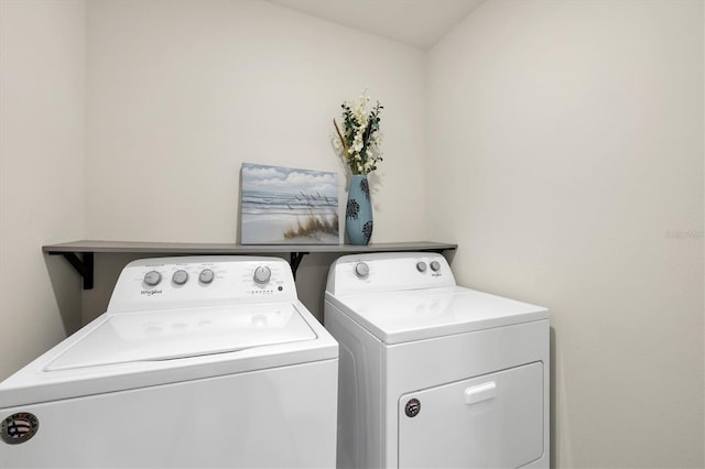 clothes washing area with washing machine and dryer