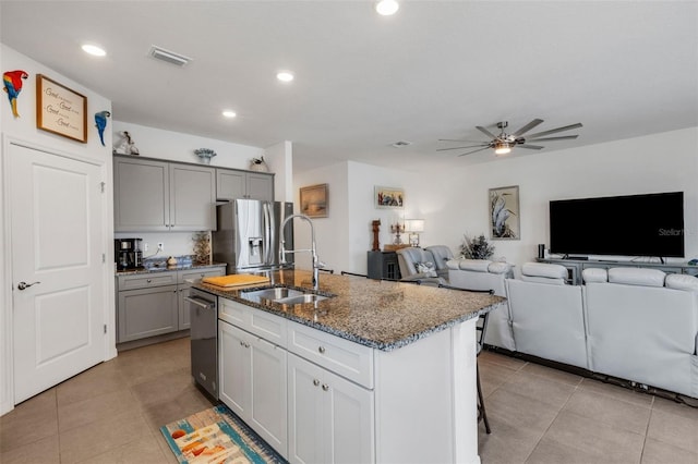 kitchen with sink, gray cabinetry, a kitchen island with sink, and stainless steel appliances