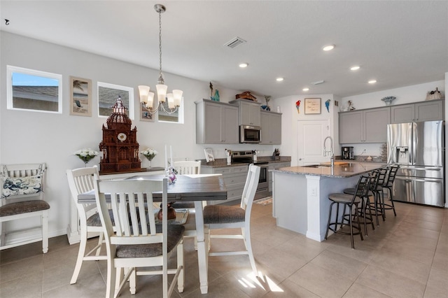 dining area with sink, light tile patterned flooring, and an inviting chandelier