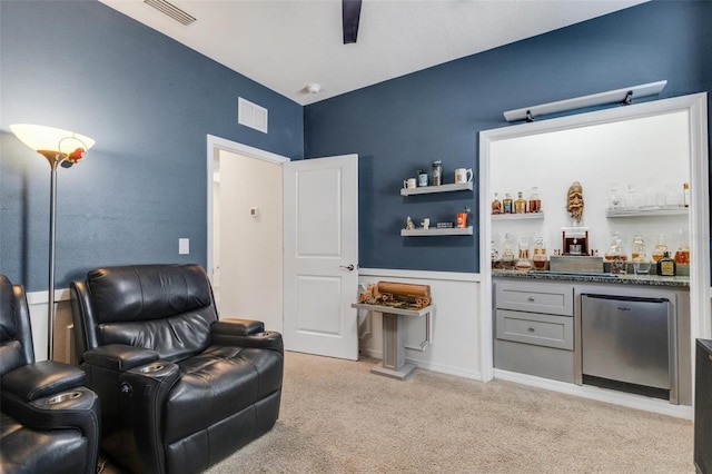 sitting room featuring bar and light colored carpet