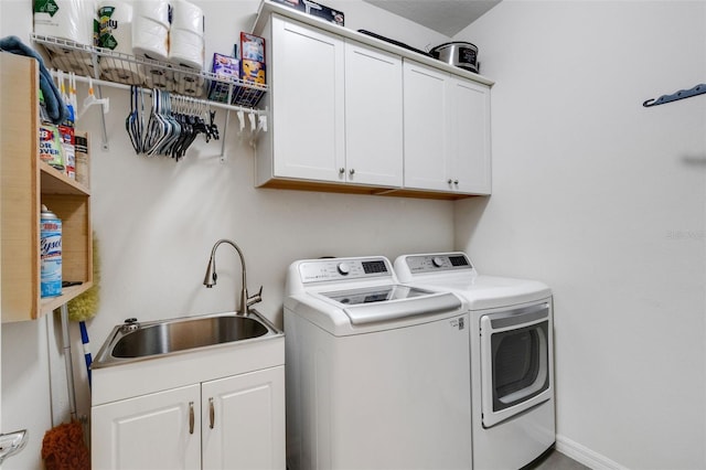 washroom featuring sink, cabinets, and washer and clothes dryer