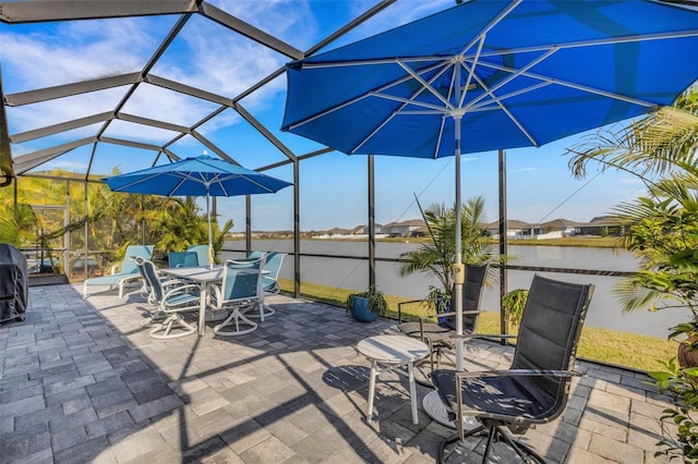 view of patio / terrace with a lanai and a water view