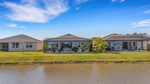 back of house featuring a lanai, a lawn, and a water view