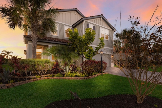 view of front of house with a garage and a lawn