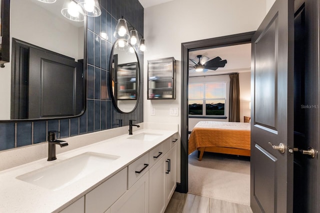 bathroom featuring hardwood / wood-style flooring, vanity, ceiling fan, and tasteful backsplash