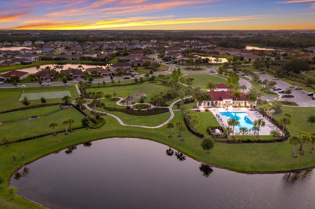 aerial view at dusk featuring a water view