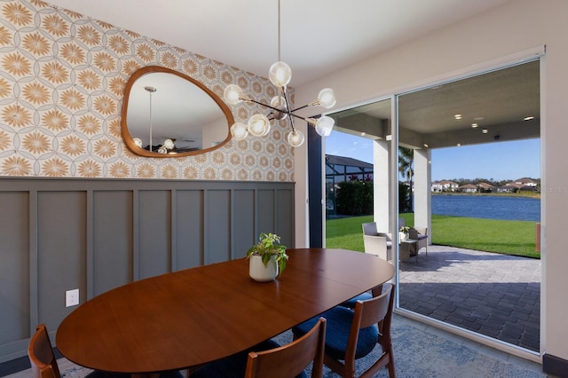 dining area with a water view and a notable chandelier