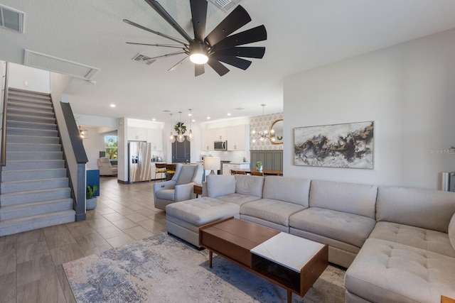 living room featuring ceiling fan with notable chandelier