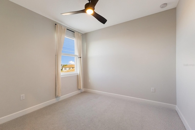 spare room featuring ceiling fan and light colored carpet